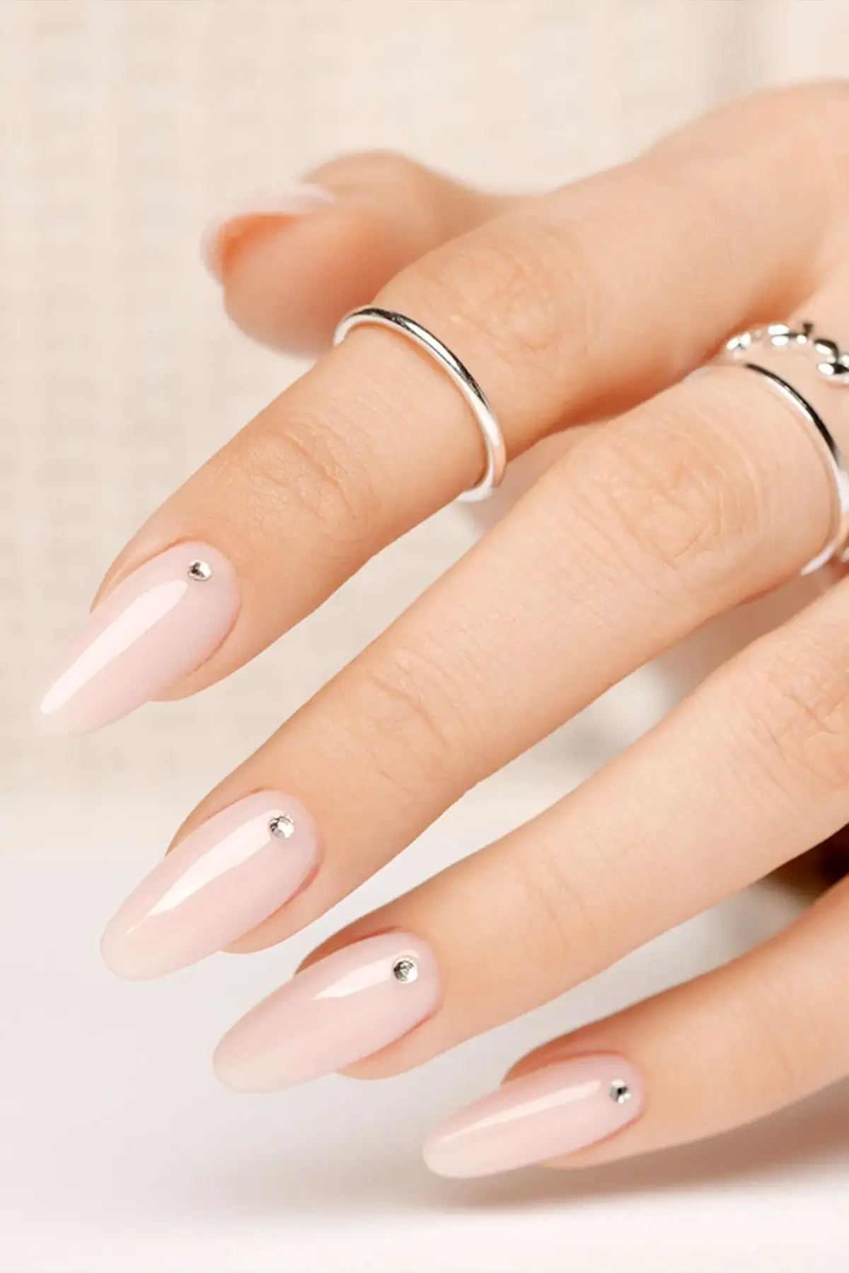 Klassische Nude-Nägel mit dezenten Glitzer-Highlights und Steinchen. Zeitlose Eleganz und professionelles Nageldesign St. Gallen.