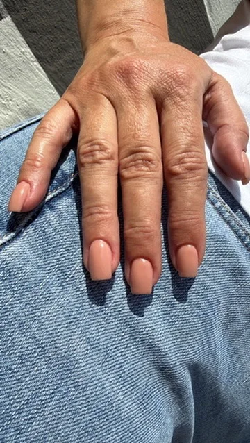 Nude-farbene Nägel an einer Hand